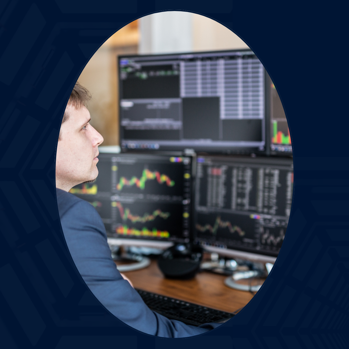 A MAN WEARING A BLUE-GREY SUIT IS SEATED AND REVIEWING STOCK MARKET INFORMATION